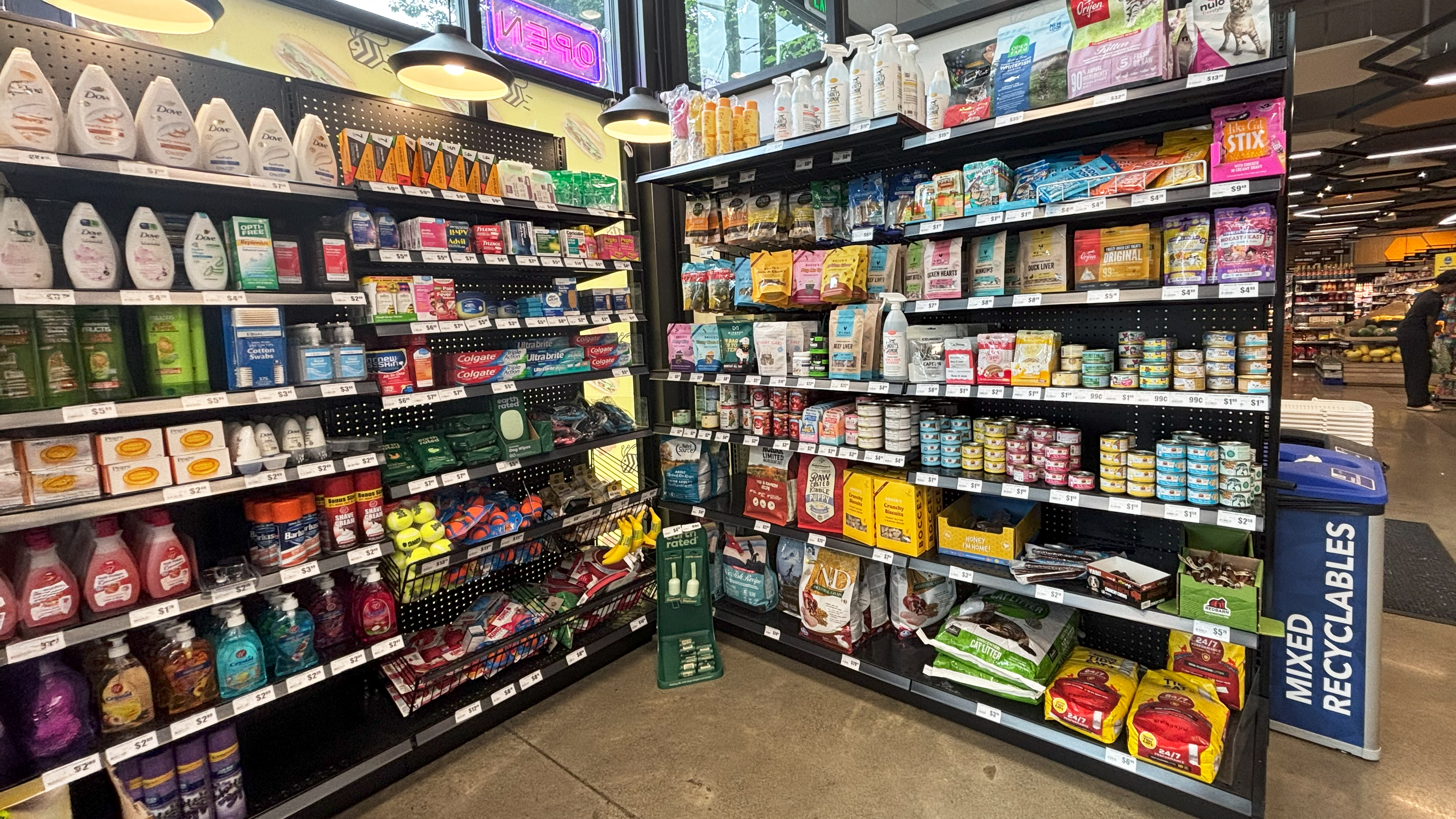 Shelves at Yellow Bee Market & Cafe in Seattle stocked with personal care, household products, and pet supplies, highlighting the store’s wide variety.